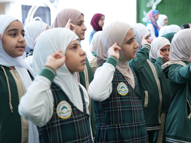 طالبات التكامل يؤدّين التحية في الطابور الصباحي
