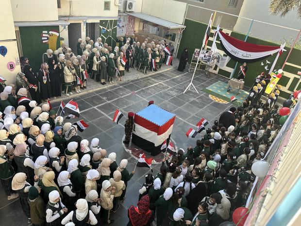 احتفال وطني في ساحة المدرسة بالأعلام العراقية