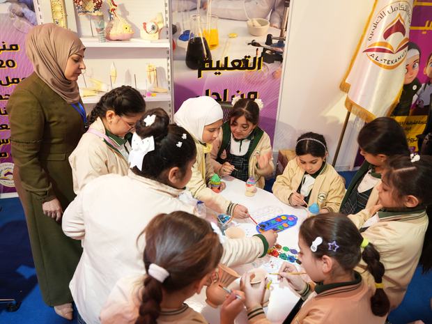 طالبات يلوّنّ القطع الخزفية في جناح المعرض