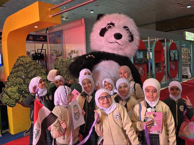 طالبات مع تميمة المعرض في جناح المجموعة