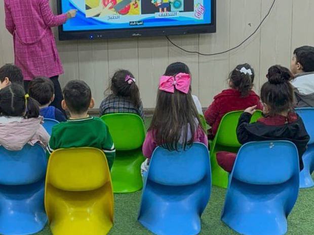 أطفال الروضة يتابعون عرضاً تعليمياً على الشاشة