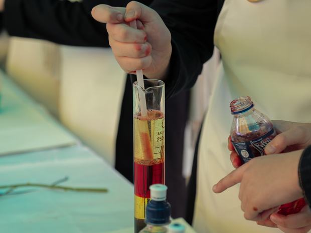 تجربة كيميائية بأنبوب مدرّج في مختبر المدرسة