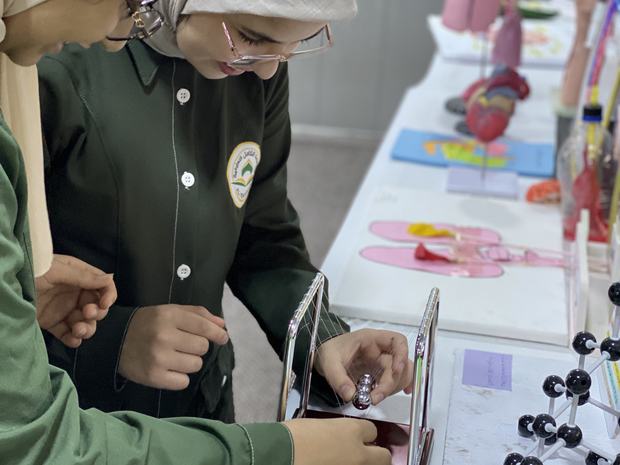 طالبة تستخدم المجسّمات الجزيئية في مختبر الكيمياء