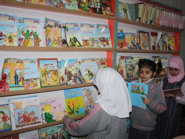 طالبات يخترن كتباً من رفوف المكتبة