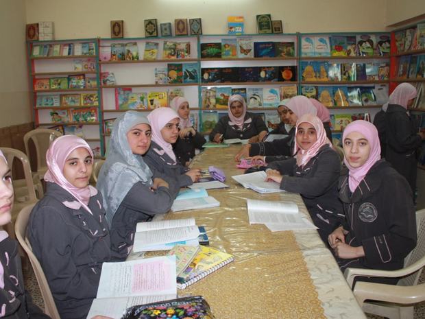 طالبات يدرسن حول طاولة المكتبة