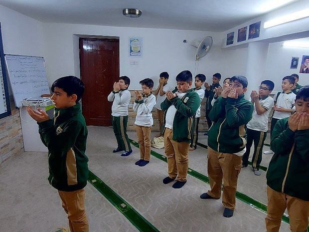 طلاب يؤدّون الصلاة في مصلّى المدرسة